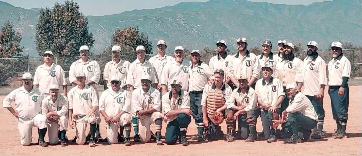 Vintage baseball team posing on field with mountains