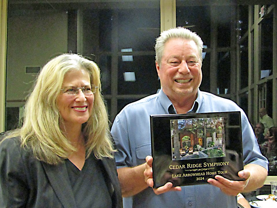 Executive Director Robin Bull presents a plaque to the Cedar Ridge Symphony homeowner