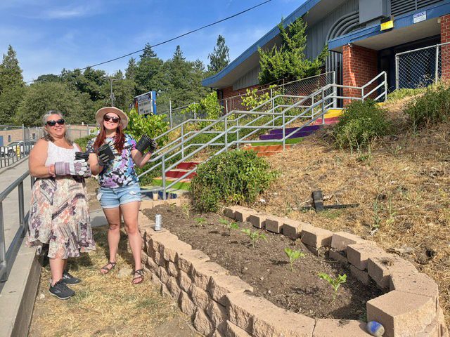 Alina Adams (left) and Paulina Lewis planting some of the many plants that were donated to the school.