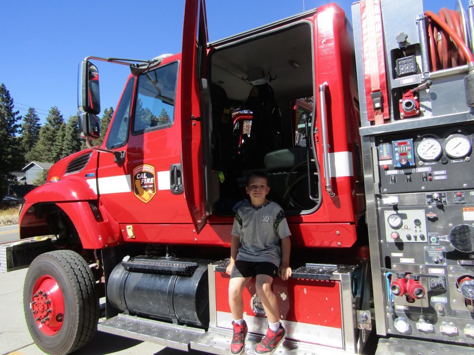Eight-year-old Kamdyn climbs down from a fire engine parked next door to the Running Springs CHP office after exploring its interior.