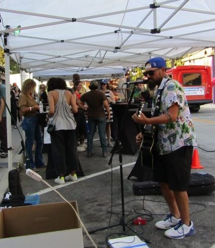 Local guitarist Ryan Dufford entertained folks on the crowded sidewalk with familiar songs.