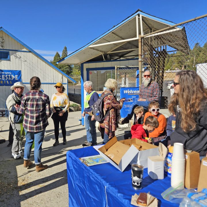 Group gathered outside a community center, sunny day.