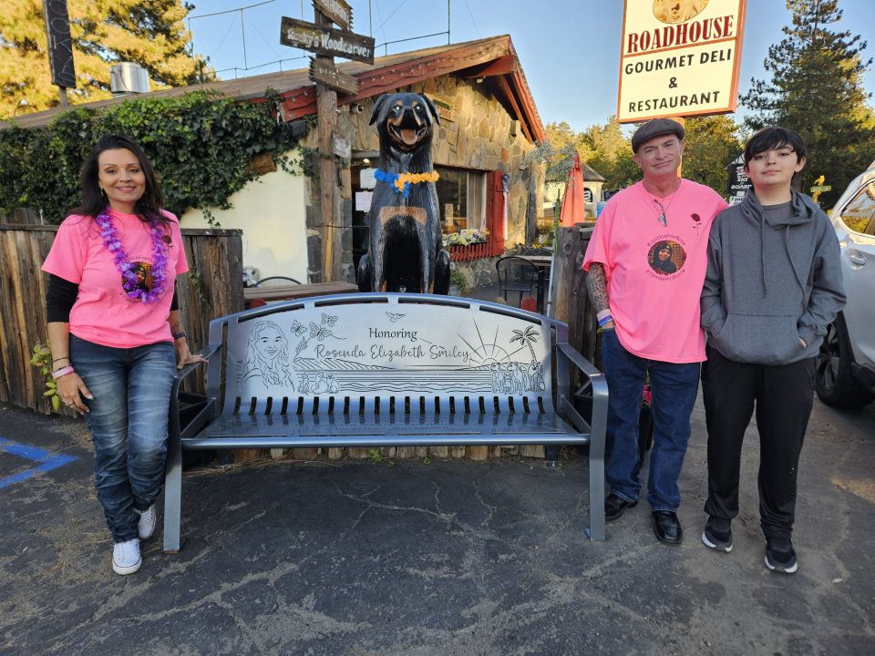 People posing by bench honoring Rosenda Elizabeth Smiley.