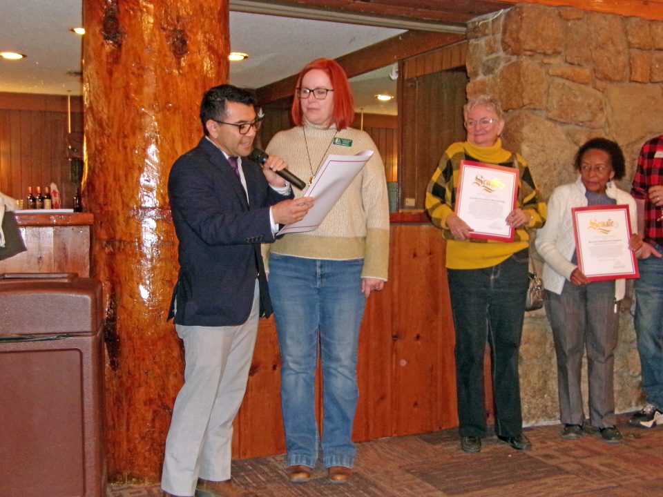 Group receiving awards in rustic event setting.