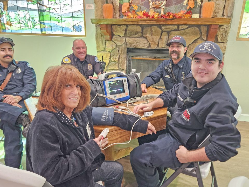 Sandy Brown has her blood pressure taken by James Ellsberry, firefighter-EMT with the Running Springs Fire Department.