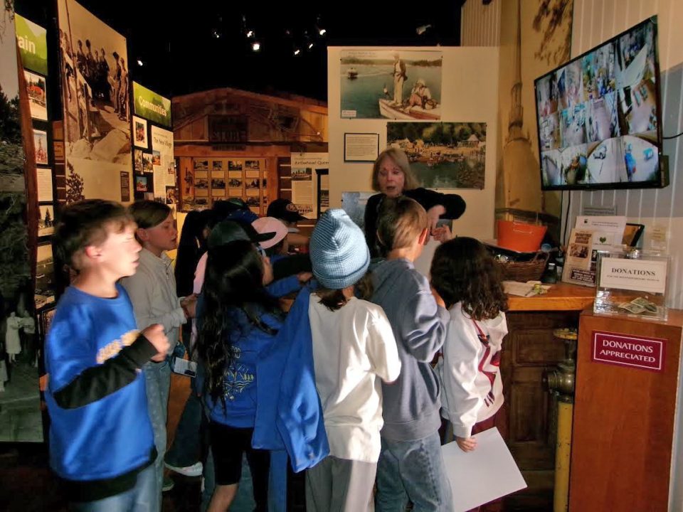 Children at museum exhibit with guide.