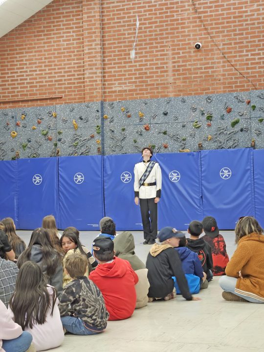 Drum Major Brenden Watson tosses his mace high into the air, drawing gasps from the elementary school students.
