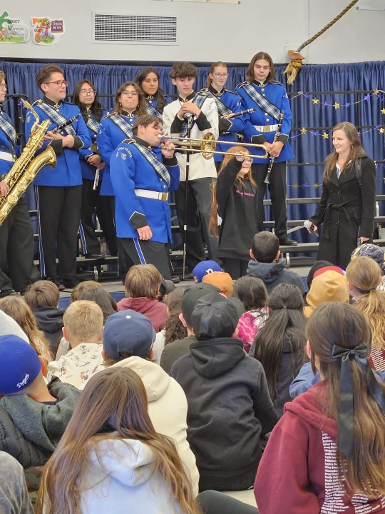 While Kaydin blows into his trombone, Colette moves the slide to create the notes.