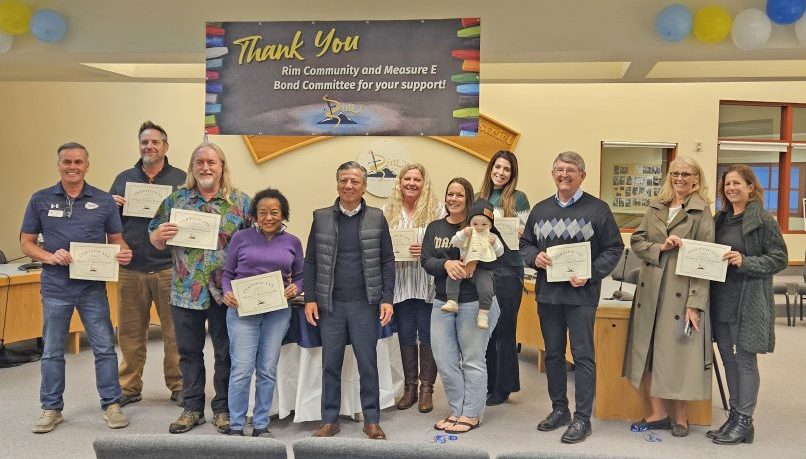 Group holding certificates at appreciation event.