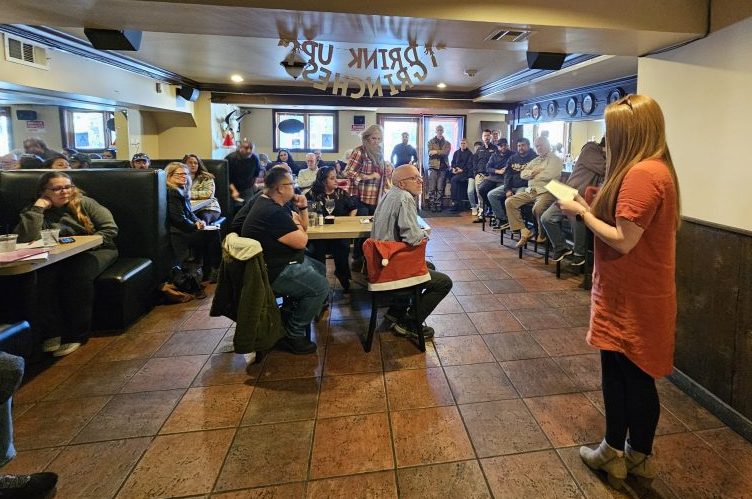 Woman speaking to a group in a restaurant.