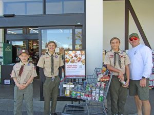 At the entrance of Stater Bros. market in Lake Arrowhead are Gauge Pennington (10), Cru Pierce (14), Alex Heitz (12) and Scoutmaster Charles DeBruyn.