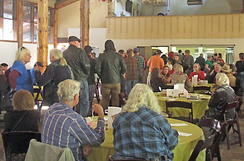 People gathered at a large indoor meeting event.