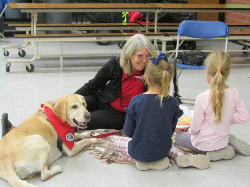 The dogs listen as the students read during this imaginative and creative program to improve reading fluency for first graders.