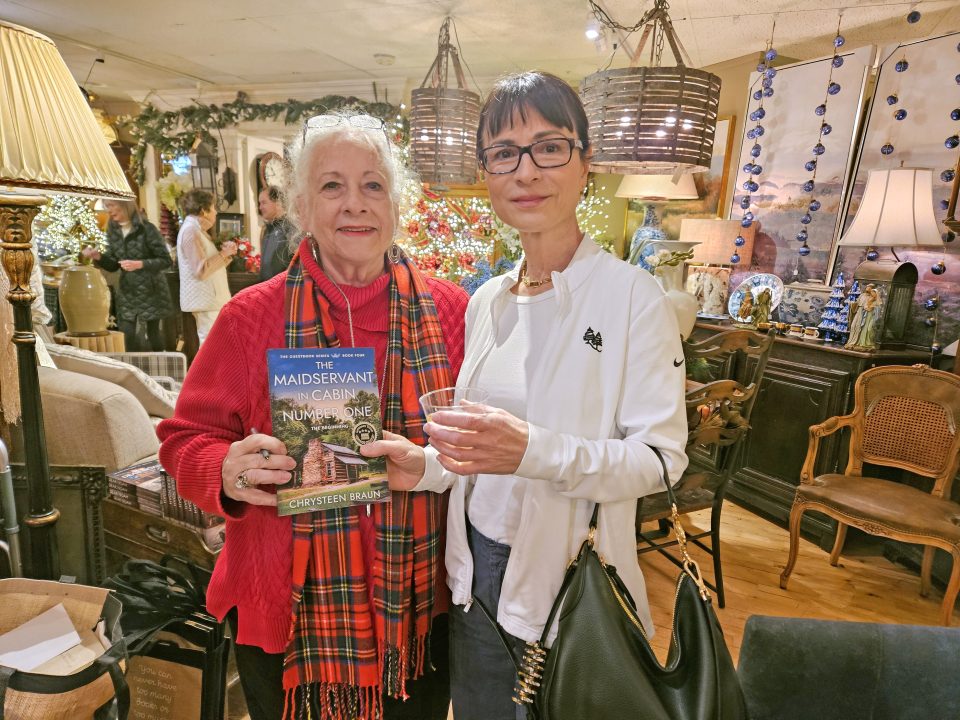 Adrianne, Lisa, Julia, Melissa and Adrianna from Glendora and Orange County enjoyed last year’s Brewfest at Tavern Bay Beach Club so much they couldn’t resist attending this year’s event. (Photos by Douglas W. Motley) Two women in cozy, decorated room holding book.