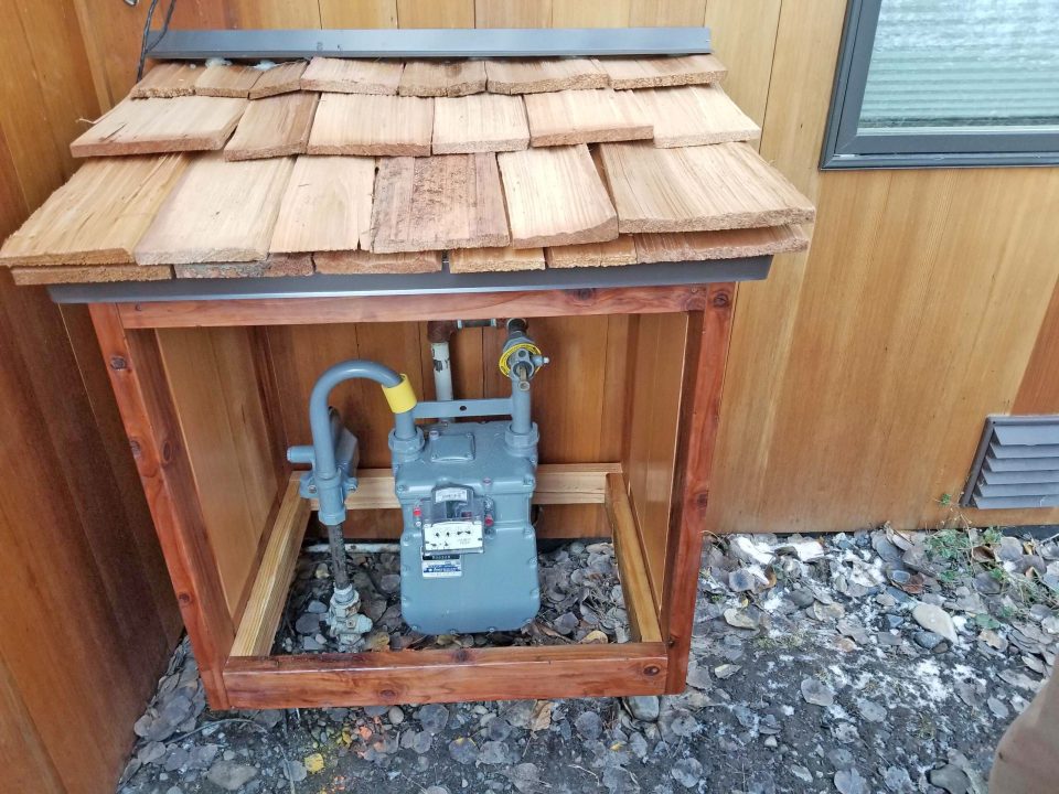 Exterior gas meter with wooden enclosure