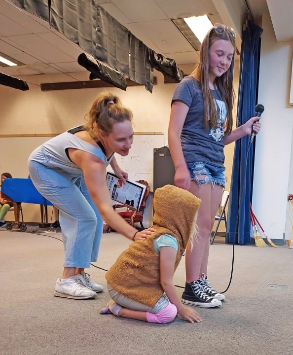 Tracey Ellert working with youth actors in Annie Jr., a recent Rim Youth Theatre production. (Photo by Julianne Homokay)