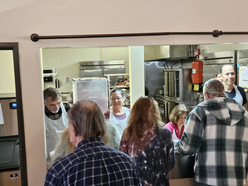 Smiling volunteers served the turkey and all the fixings at the San Moritz Lodge. (Photo by Mary-Justine Lanyon)