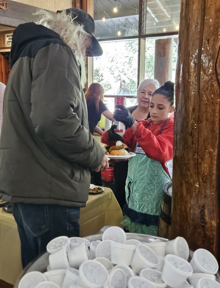 Anna adds some whipped cream to the first guest’s pie. (Photo by Mary-Justine Lanyon)