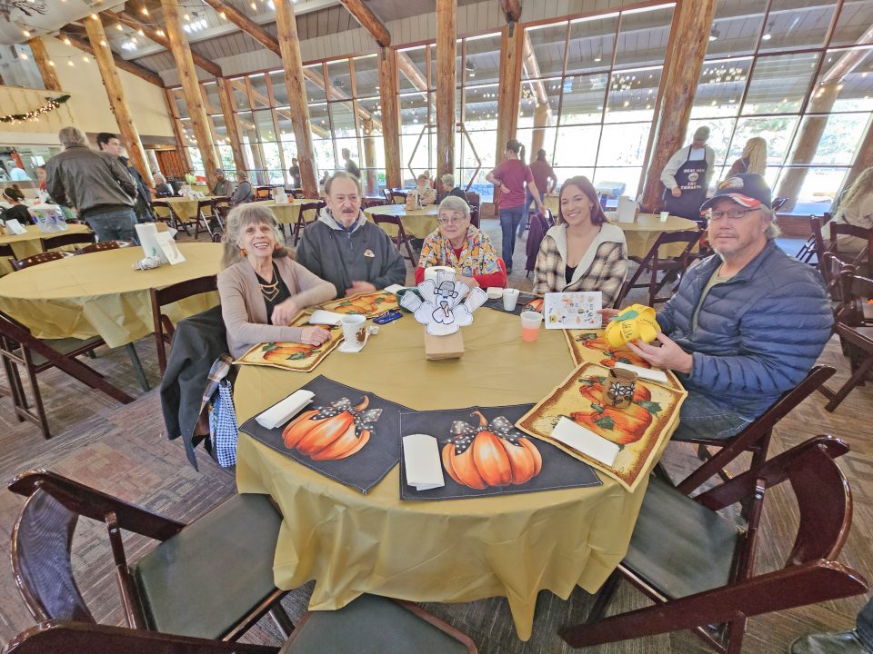 The folks at this table brought their own placemats to complement the turkey, greeting card and pumpkin made by the EarlyAct students. (Photo by Mary-Justine Lanyon)