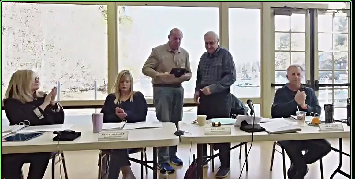 Meeting of five people at a conference table.