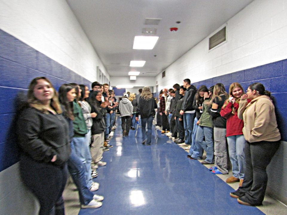 Students line hallway for school event.