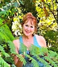 Woman smiling in lush green garden.