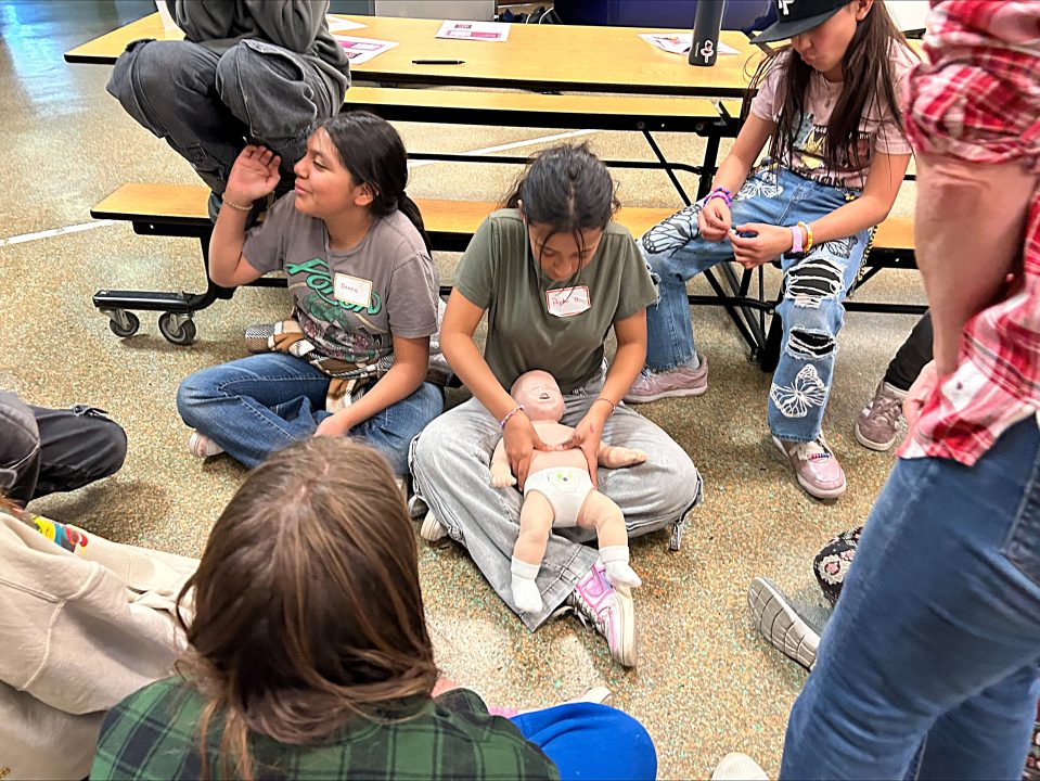 The girls also practiced CPR on dolls, representing babies. (Photo by Cheryl Robinson)