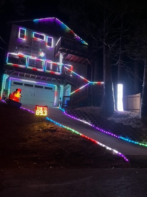 House decorated with colorful Christmas lights at night.