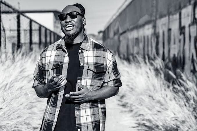 Man in plaid shirt walking outdoors, black and white.