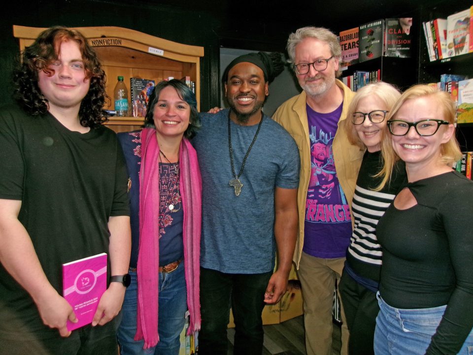 Group photo in a bookstore. Smiling people.