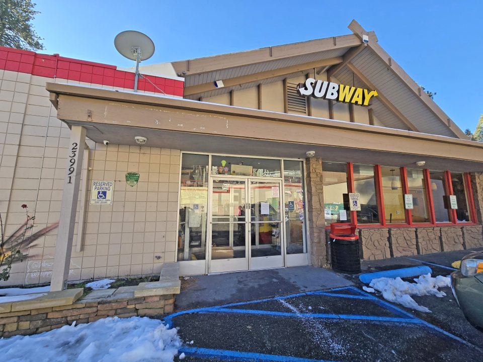 Subway restaurant entrance with accessible parking sign.