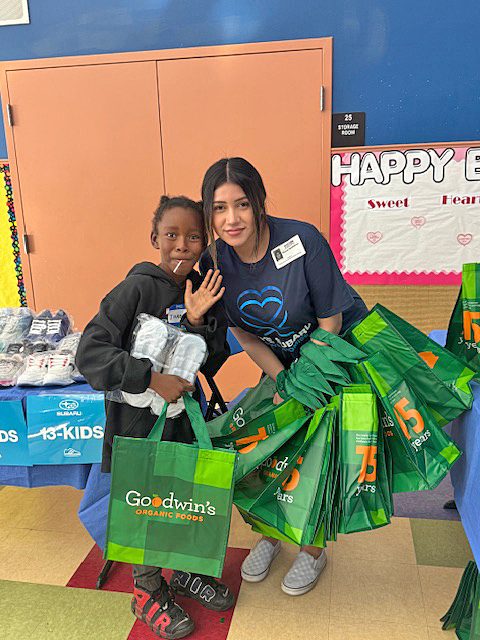 Blanca Ruizbeltran of the Boys & Girls Club of Greater Redlands with one of the recipients of the shoes and other items Subaru of San Bernardino donated.