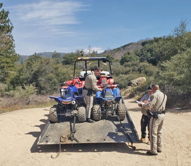 Adrianne, Lisa, Julia, Melissa and Adrianna from Glendora and Orange County enjoyed last year’s Brewfest at Tavern Bay Beach Club so much they couldn’t resist attending this year’s event. (Photos by Douglas W. Motley) Officers inspecting ATVs on a trailer in forest.