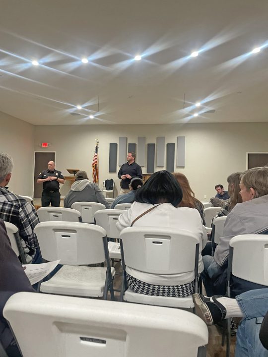 Community meeting with speakers addressing audience.