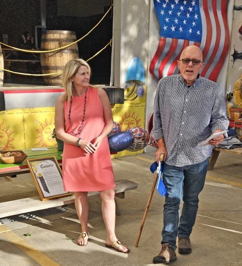 Two people at outdoor event with American flag.