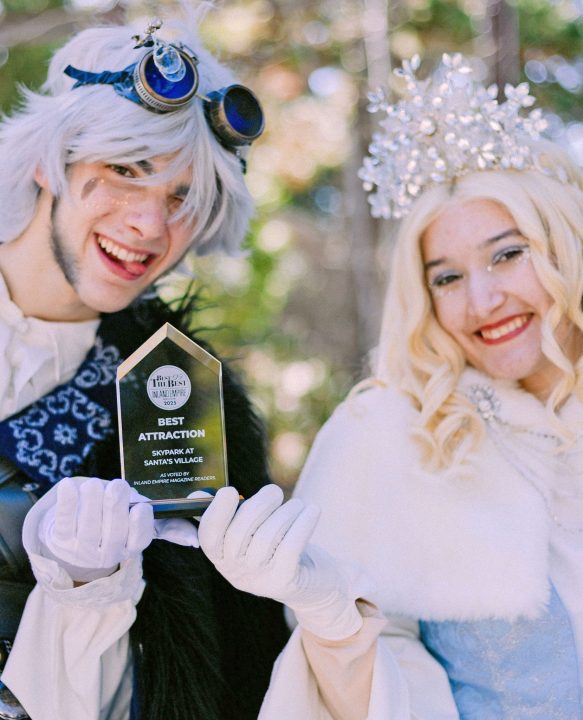 Cosplay characters holding best attraction award trophy.