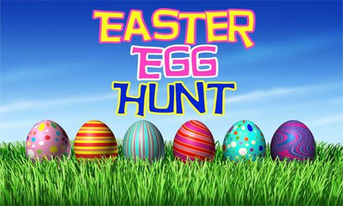 Colorful Easter eggs on grass with blue sky background.