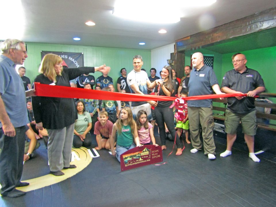 Group at ribbon-cutting ceremony indoors with children.