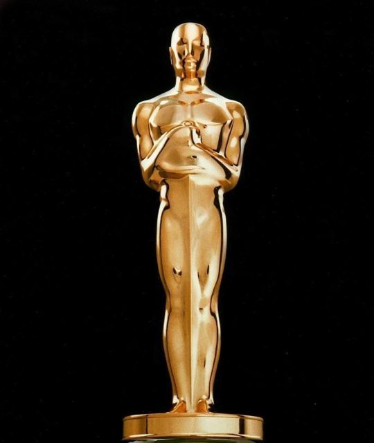 Golden trophy statue on black background