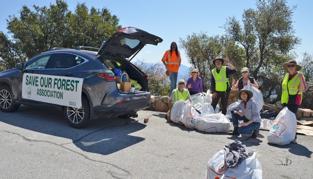 Adrianne, Lisa, Julia, Melissa and Adrianna from Glendora and Orange County enjoyed last year’s Brewfest at Tavern Bay Beach Club so much they couldn’t resist attending this year’s event. (Photos by Douglas W. Motley) Volunteers cleaning forest roadside, standing with trash bags.