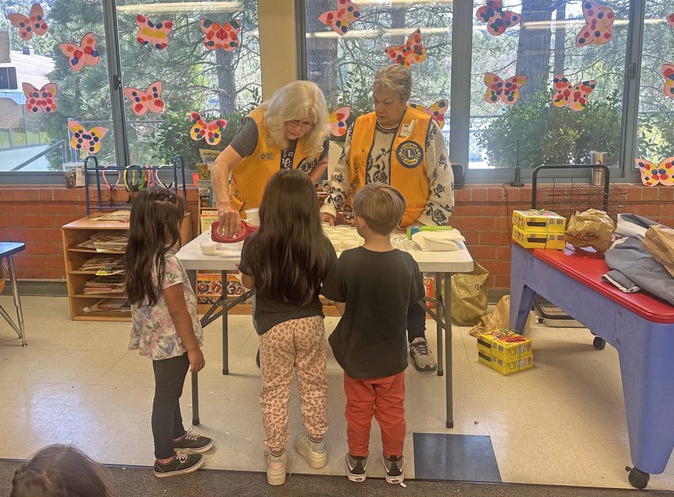 Children and adults craft at school activity table.