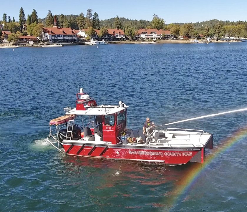 Fire rescue boat spraying water on lake.