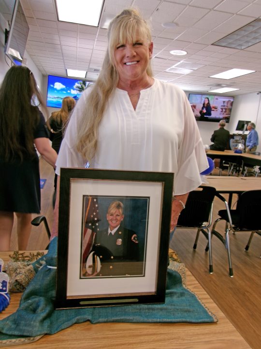 Adrianne, Lisa, Julia, Melissa and Adrianna from Glendora and Orange County enjoyed last year’s Brewfest at Tavern Bay Beach Club so much they couldn’t resist attending this year’s event. (Photos by Douglas W. Motley) Smiling woman with framed firefighter photo on table.