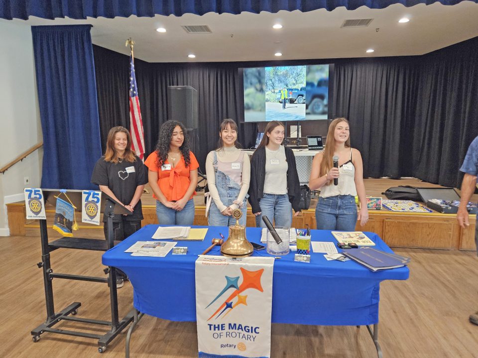 Five people presenting at Rotary event.
