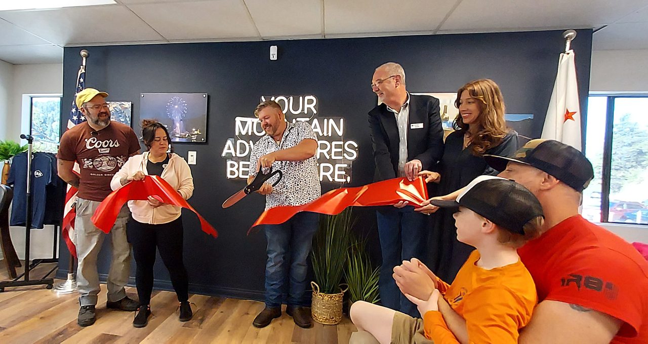 Ribbon cutting ceremony with several smiling people.