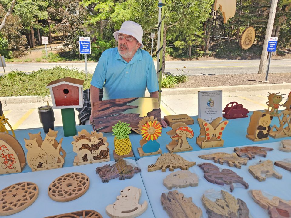 Adrianne, Lisa, Julia, Melissa and Adrianna from Glendora and Orange County enjoyed last year’s Brewfest at Tavern Bay Beach Club so much they couldn’t resist attending this year’s event. (Photos by Douglas W. Motley) Vendor with wooden crafts at outdoor market.