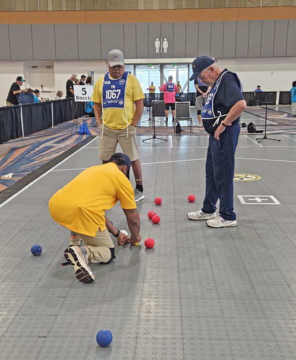 Players discussing boccia strategies on the court