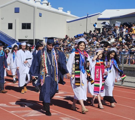 Students celebrate graduation in festive robes and caps.