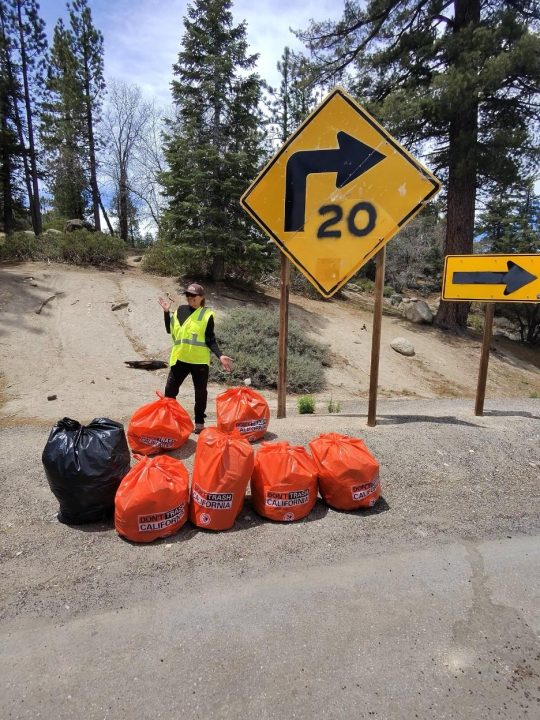 Adrianne, Lisa, Julia, Melissa and Adrianna from Glendora and Orange County enjoyed last year’s Brewfest at Tavern Bay Beach Club so much they couldn’t resist attending this year’s event. (Photos by Douglas W. Motley) Volunteer with collected trash bags near road sign.