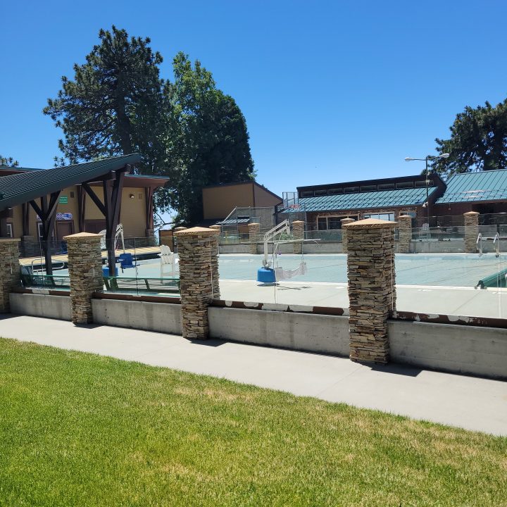 Outdoor pool with stone pillars and trees
